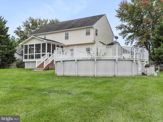 back of house featuring an outdoor pool, a sunroom, a yard, and a wooden deck