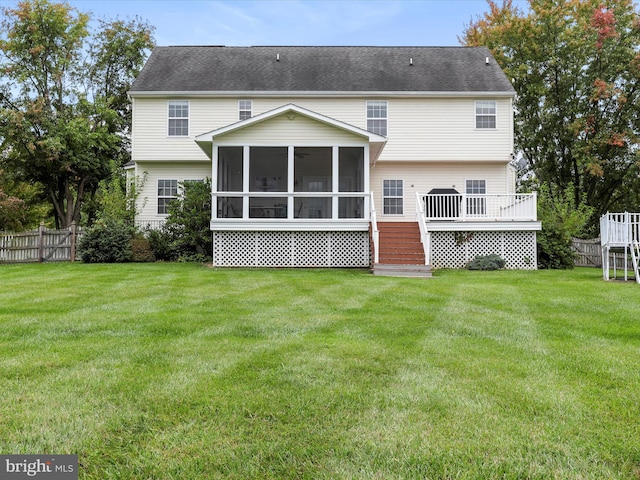 back of house featuring a yard, a sunroom, fence, and a wooden deck