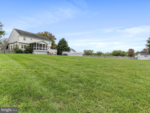 view of yard with fence and a sunroom