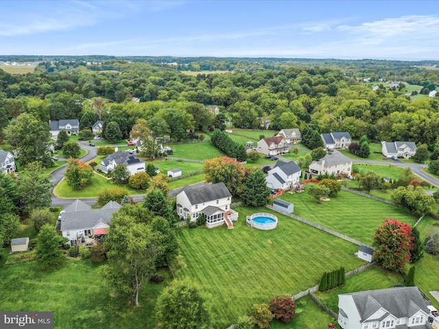 birds eye view of property featuring a residential view and a wooded view