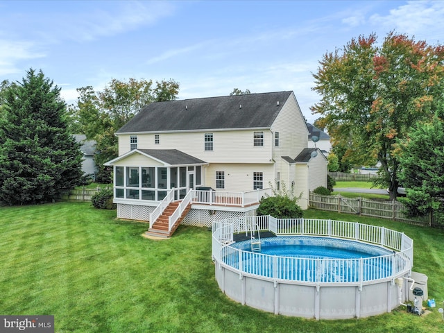 back of house with a fenced in pool, a lawn, a sunroom, a fenced backyard, and stairs