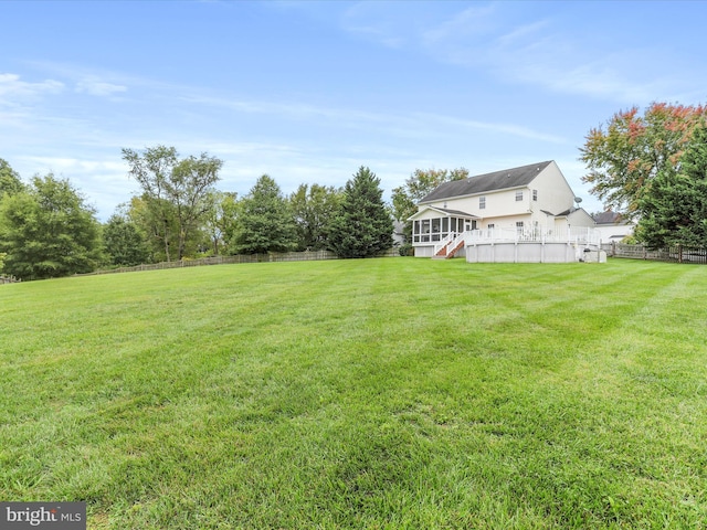 view of yard featuring a sunroom and fence