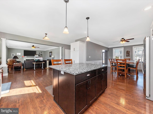 kitchen featuring ornate columns, crown molding, dark wood-type flooring, and freestanding refrigerator