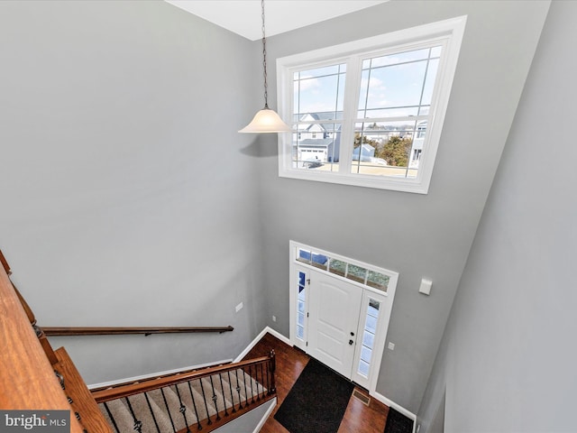 foyer entrance featuring visible vents, stairway, baseboards, and wood finished floors