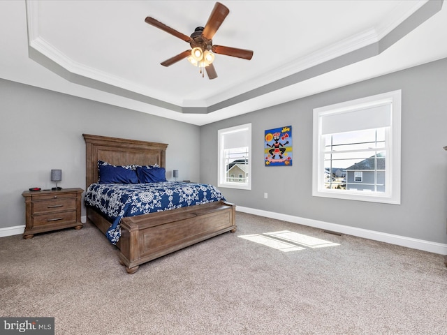 carpeted bedroom featuring a tray ceiling, baseboards, and visible vents