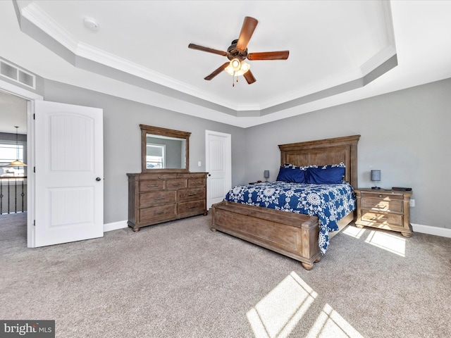 bedroom with baseboards, a tray ceiling, carpet floors, and visible vents