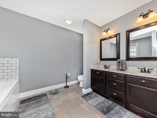 bathroom with a bathing tub, toilet, baseboards, and a sink