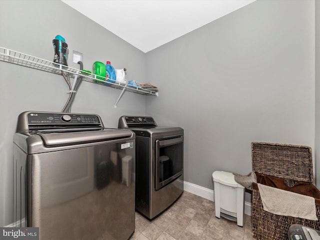 washroom with baseboards, independent washer and dryer, and laundry area