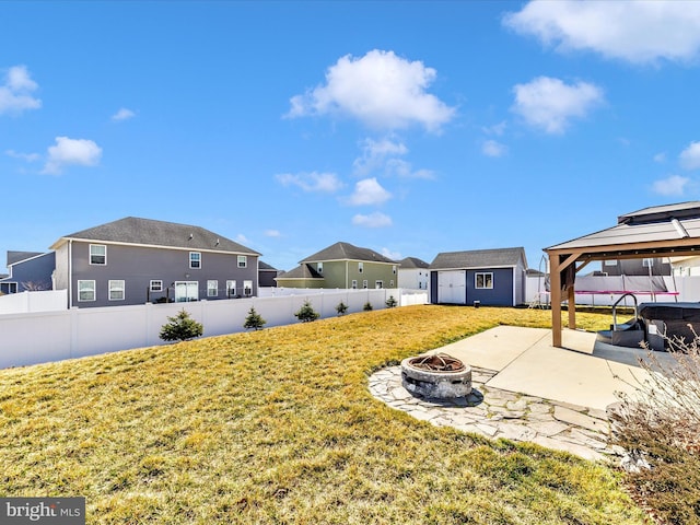 view of yard with an outdoor fire pit, a gazebo, a fenced backyard, an outdoor structure, and a patio