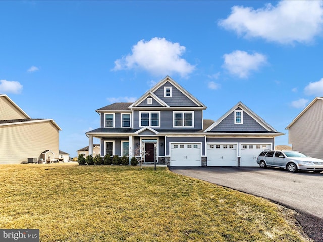 view of front facade featuring a front lawn, a garage, and driveway