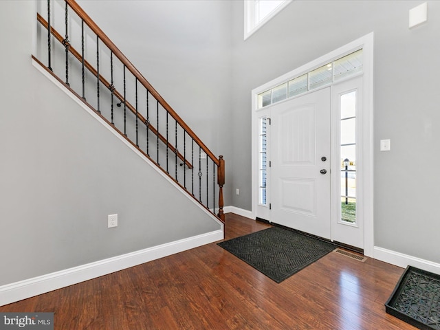 entrance foyer with a high ceiling, wood finished floors, and baseboards