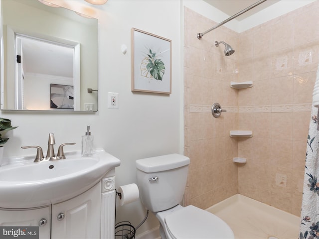 bathroom featuring tiled shower, vanity, and toilet