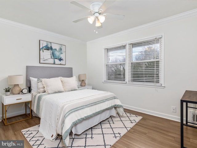 bedroom featuring ornamental molding, ceiling fan, baseboards, and wood finished floors