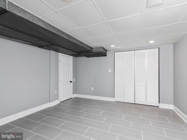 finished basement with recessed lighting, a drop ceiling, visible vents, and baseboards