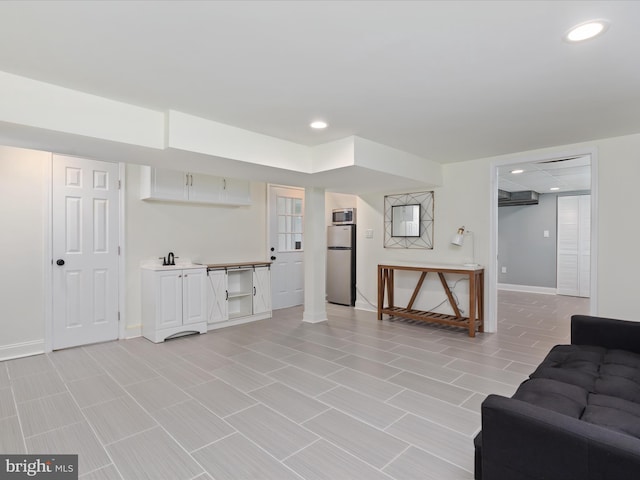 living room featuring baseboards, an AC wall unit, and recessed lighting