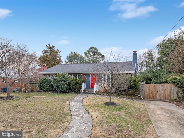 view of front of house with entry steps, fence, and a front yard