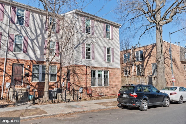 view of property featuring a fenced front yard and brick siding