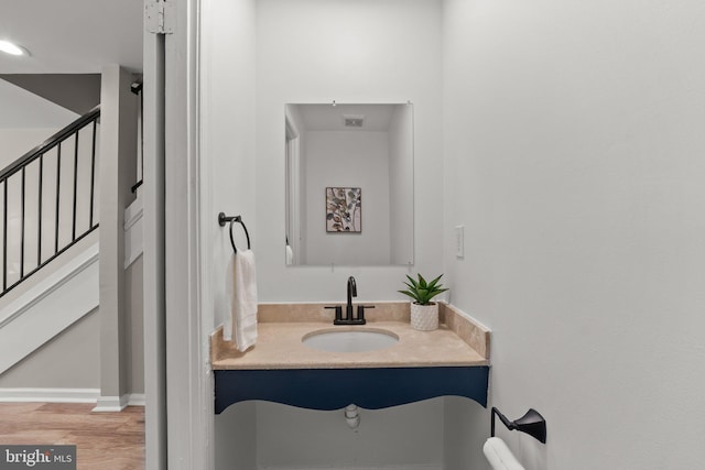 bathroom with vanity, wood finished floors, visible vents, and baseboards