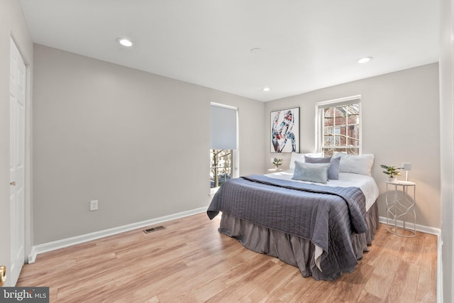 bedroom with light wood finished floors, baseboards, visible vents, and recessed lighting