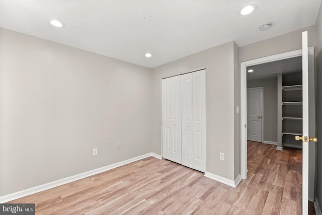 unfurnished bedroom with light wood-style floors, recessed lighting, and baseboards