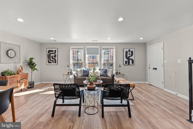 living room with recessed lighting, light wood-style flooring, and baseboards