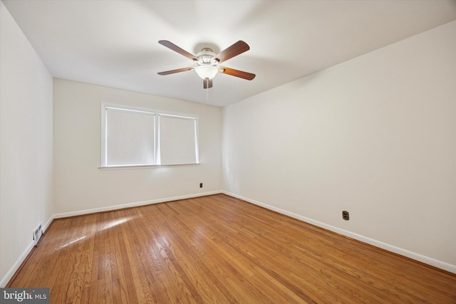 unfurnished room with ceiling fan, baseboards, and light wood-style flooring