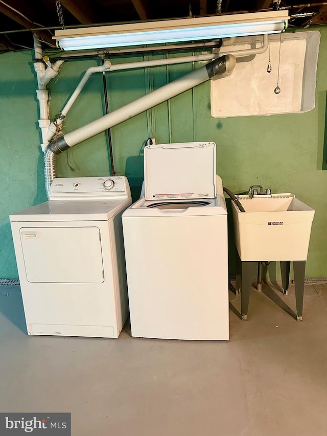 laundry area featuring a sink, laundry area, and washer and clothes dryer