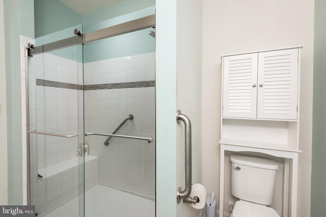 bathroom featuring toilet and a shower stall