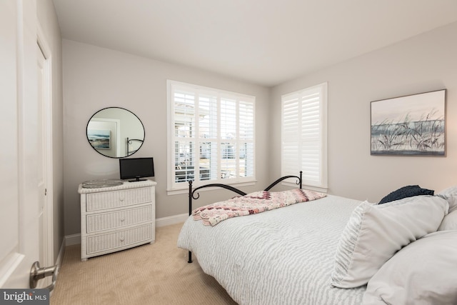 bedroom with light carpet and baseboards