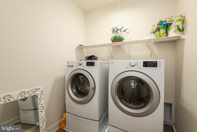 clothes washing area featuring laundry area, independent washer and dryer, and baseboards