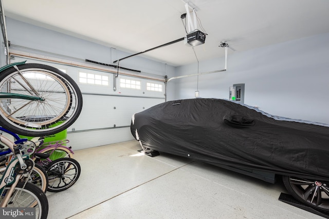 garage with a garage door opener and electric panel