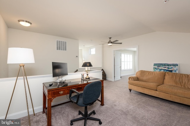 office featuring light carpet, a ceiling fan, visible vents, vaulted ceiling, and baseboards