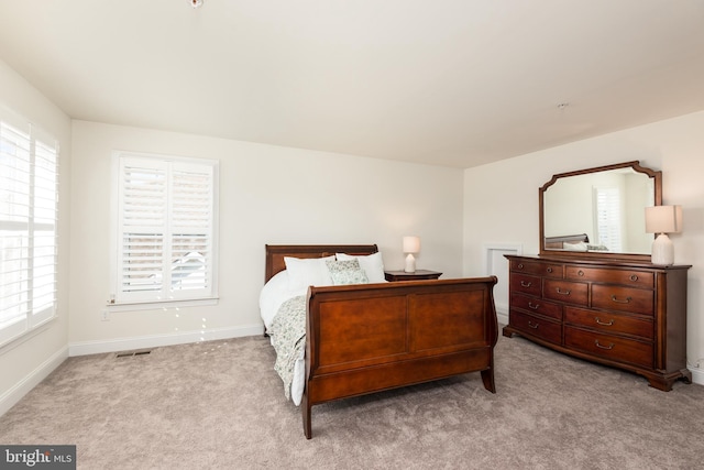 bedroom featuring carpet, visible vents, baseboards, and multiple windows