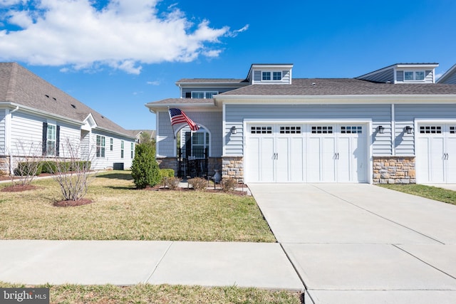 view of front of house featuring a garage, stone siding, a front lawn, and concrete driveway