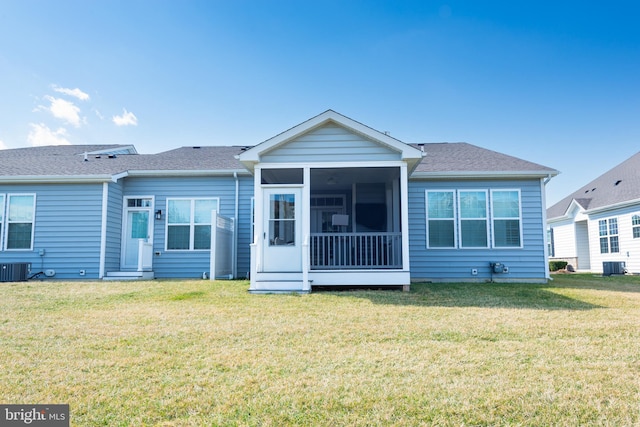 back of house with a shingled roof, cooling unit, a sunroom, and a yard