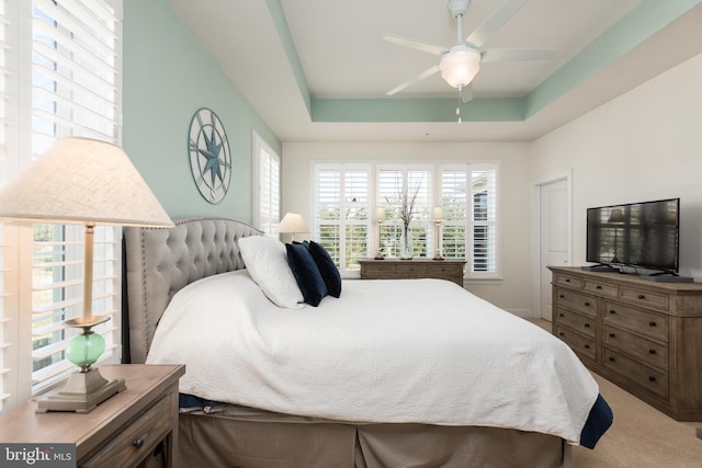 bedroom featuring carpet floors, ceiling fan, and a raised ceiling