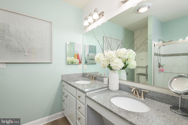 full bathroom with a stall shower, toilet, vanity, and baseboards