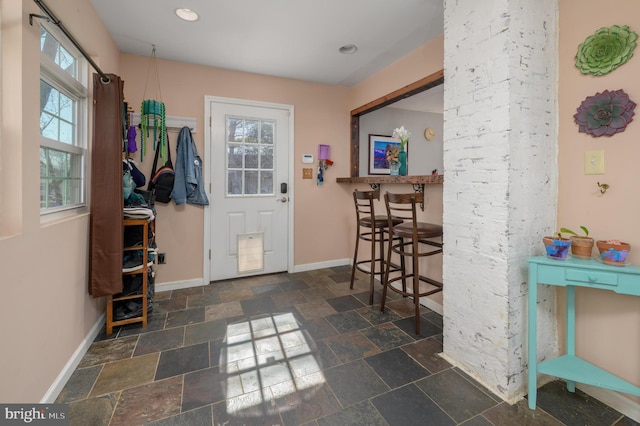 entryway featuring recessed lighting, baseboards, and stone tile flooring