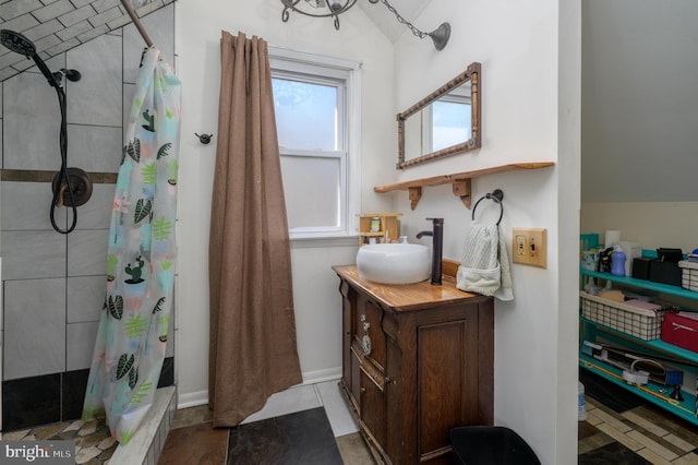 full bathroom with vaulted ceiling, vanity, and a tile shower