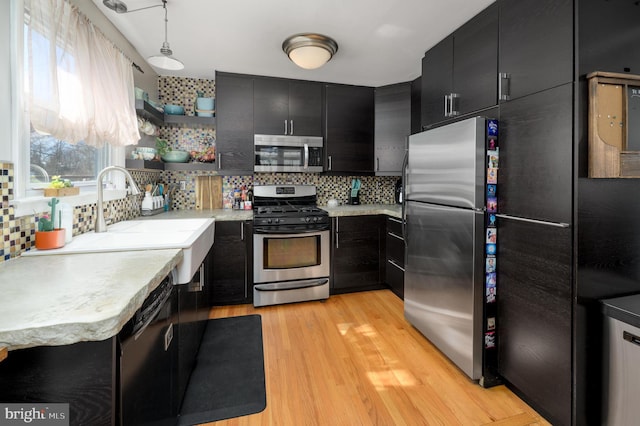 kitchen featuring stainless steel appliances, dark cabinets, and light countertops