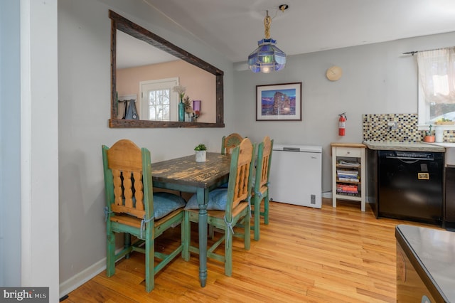 dining space featuring baseboards and light wood-style floors