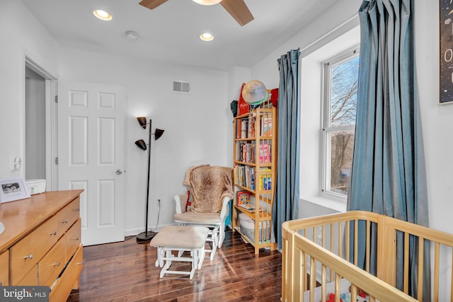 bedroom featuring recessed lighting, visible vents, a crib, and dark wood-style floors