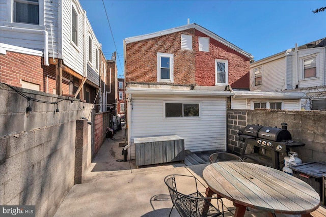 back of property with brick siding, a fenced backyard, and a patio area