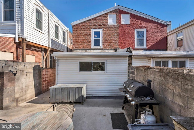 back of property with a patio area, brick siding, and fence