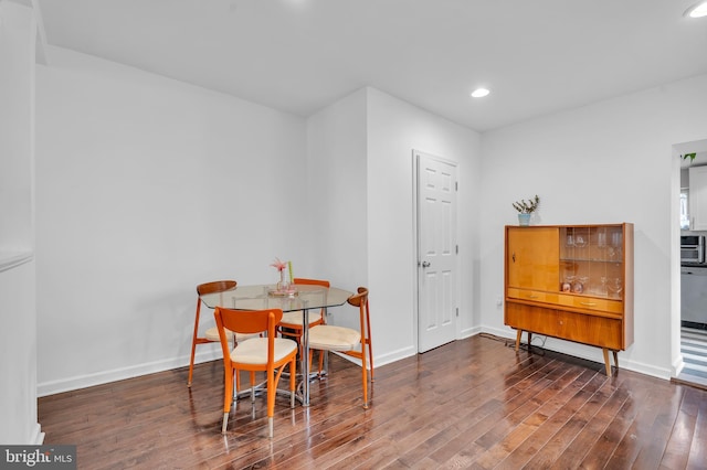 dining room with hardwood / wood-style floors, recessed lighting, and baseboards