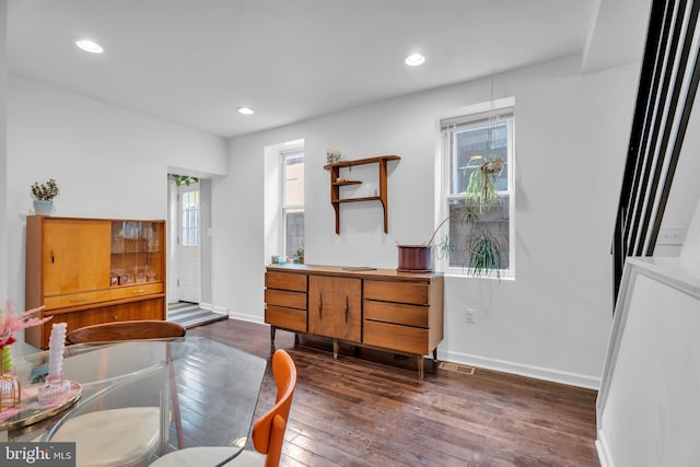 interior space featuring baseboards, plenty of natural light, and dark wood finished floors