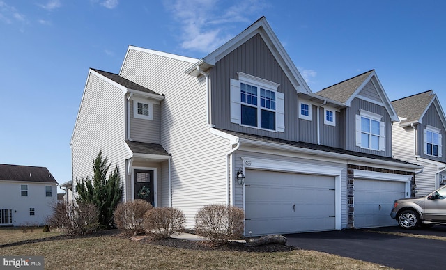 view of front of house with a garage, board and batten siding, and aphalt driveway