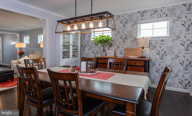 dining room featuring wallpapered walls, baseboards, wood-type flooring, and ornamental molding