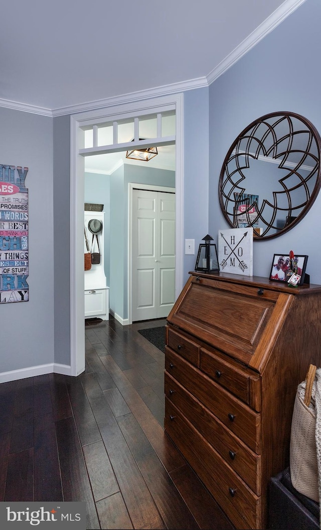 corridor with dark wood-style floors, baseboards, and ornamental molding