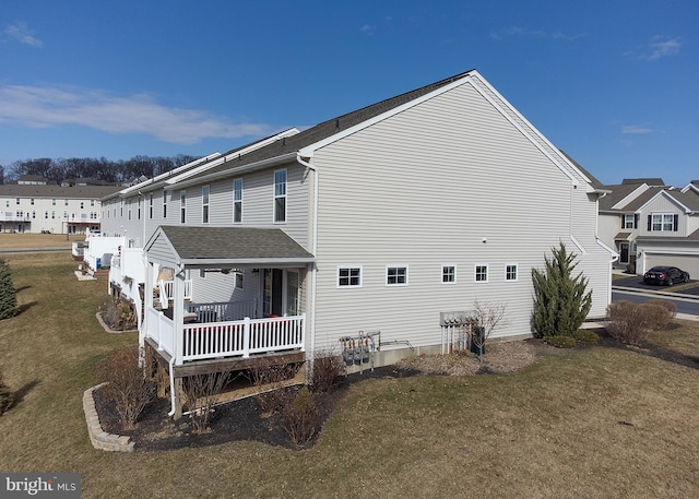 view of side of property featuring a lawn and a residential view